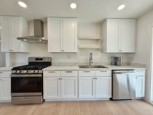 a kitchen with white cabinets and appliances