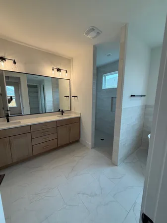 a bathroom with a double vanity sink mirror and toilet