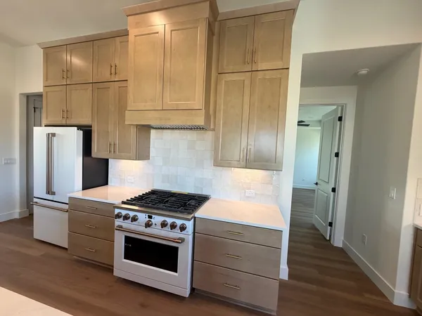 a kitchen with stainless steel appliances granite countertop a refrigerator and a stove