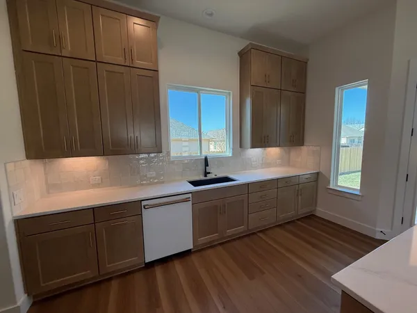 a kitchen with sink cabinets and wooden floor