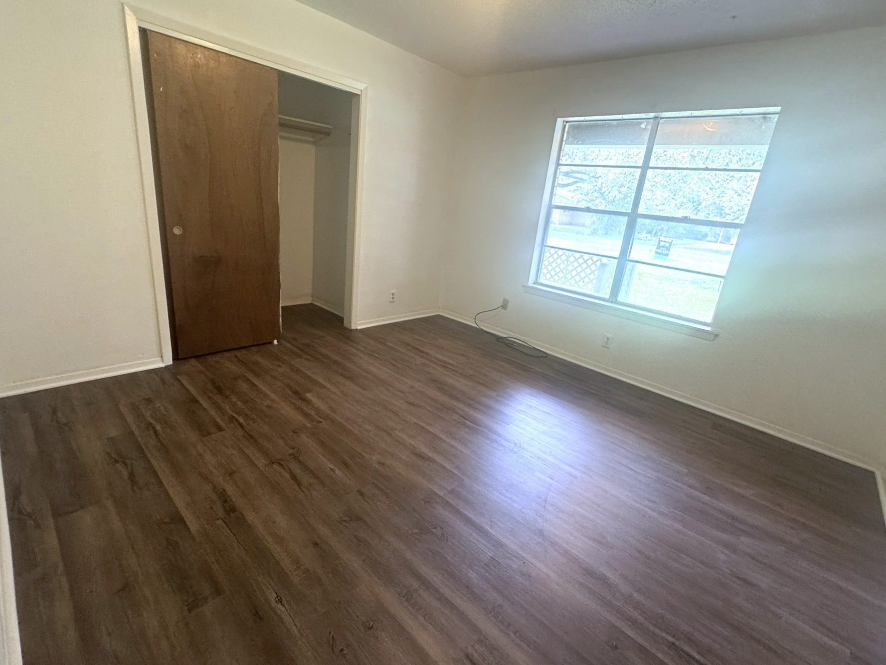 706 University Avenue Wharton, TX 77488 - Photo 13 of 29 an empty room with wooden floor and windows