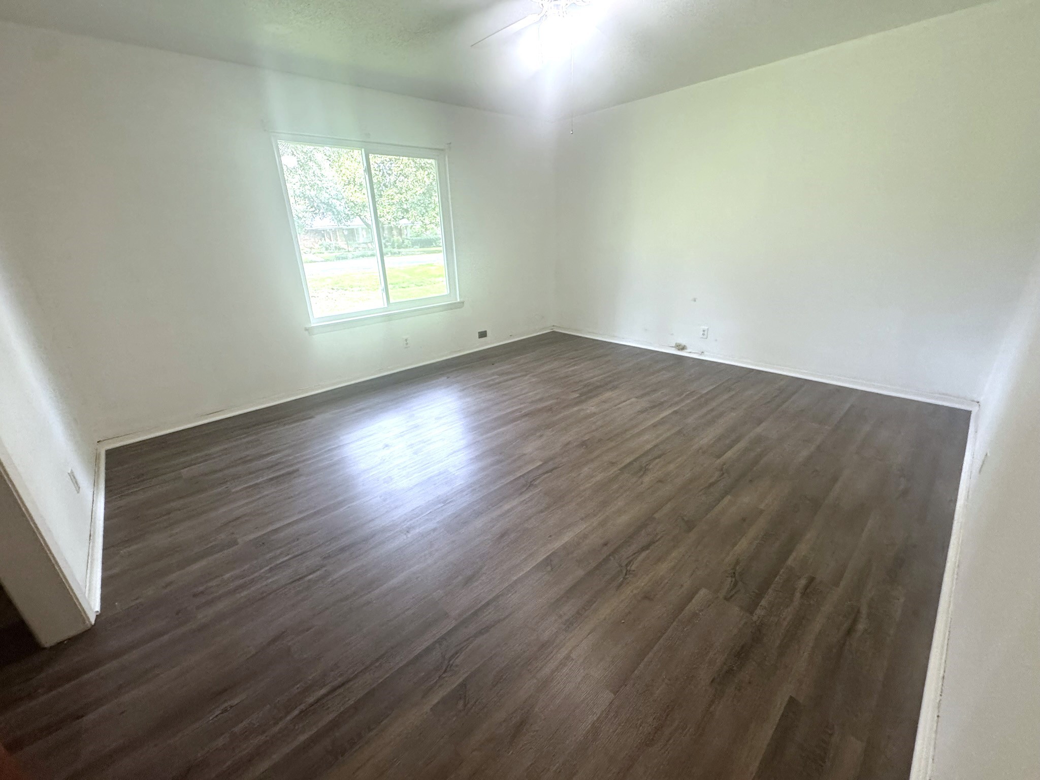 706 University Avenue Wharton, TX 77488 - Photo 16 of 29 an empty room with wooden floor and windows