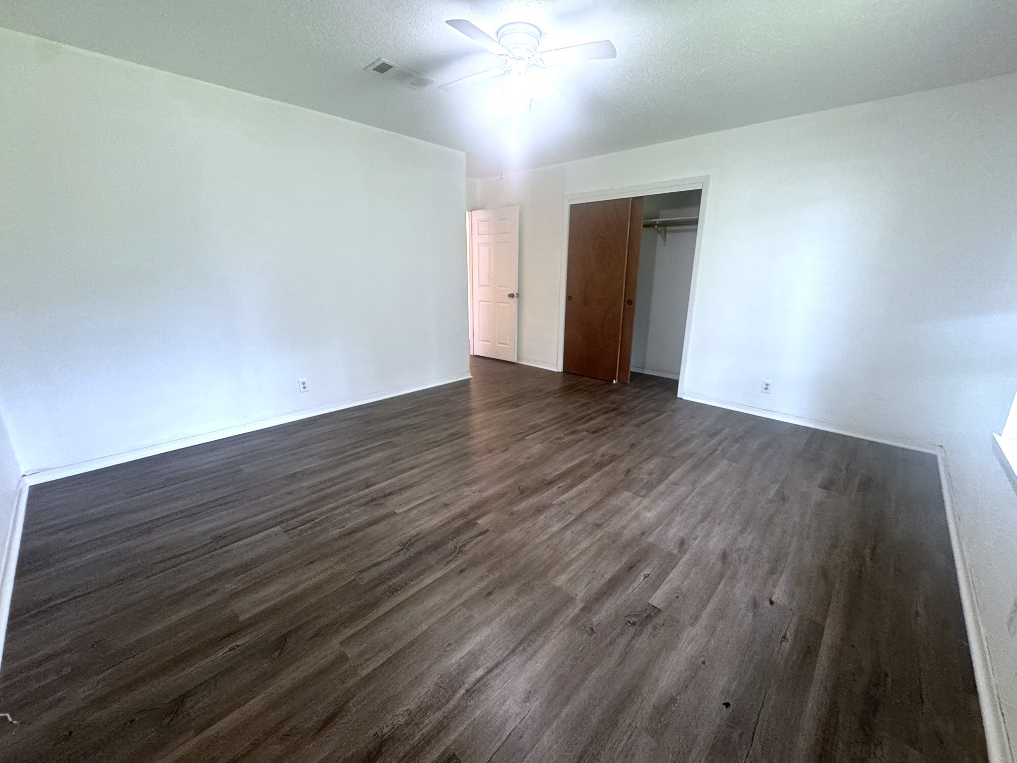 706 University Avenue Wharton, TX 77488 - Photo 17 of 29 a view of an empty room with wooden floor and a ceiling fan