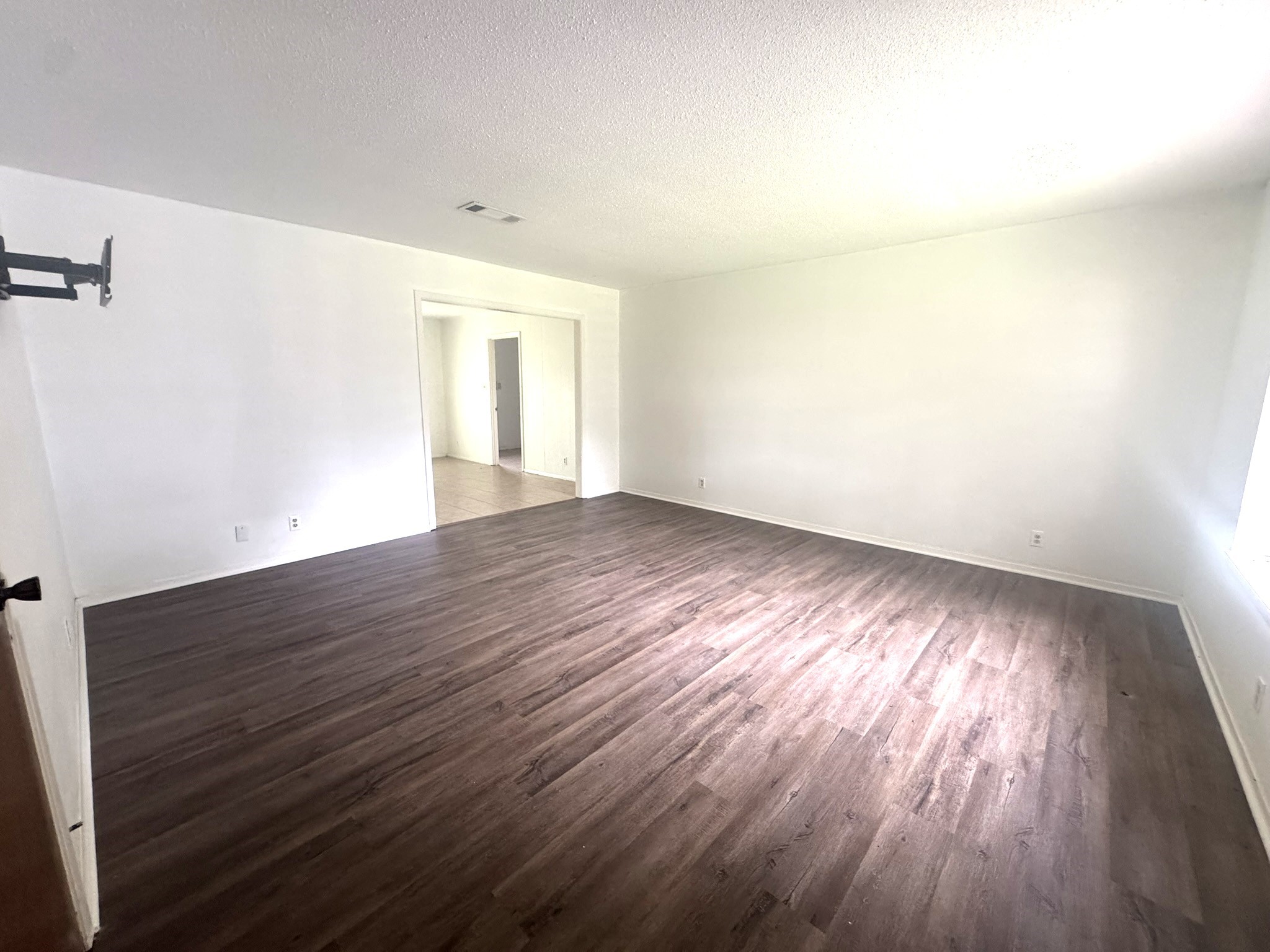 706 University Avenue Wharton, TX 77488 - Photo 2 of 29 an empty room with wooden floor and windows
