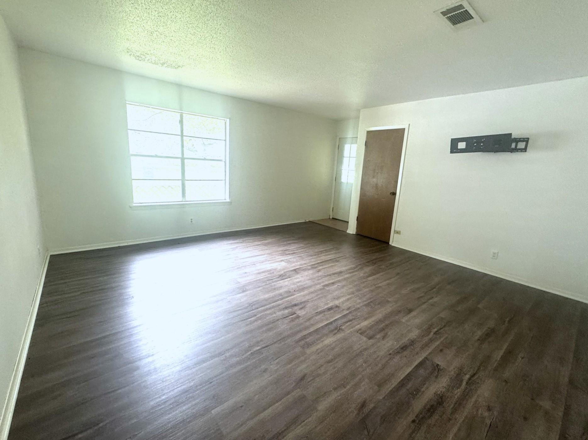 706 University Avenue Wharton, TX 77488 - Photo 3 of 29 an empty room with wooden floor cabinet and windows