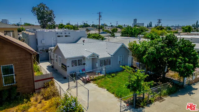 a aerial view of a house with a big yard and potted plants