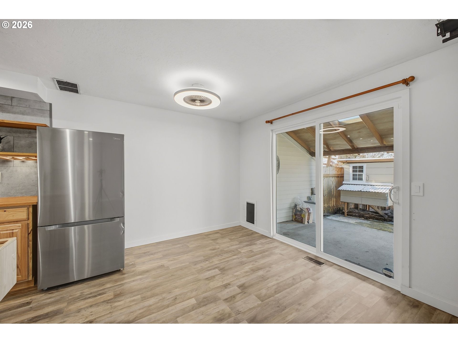 21858 Southwest Regal Court Beaverton, OR 97003 - Photo 12 of 29 a empty room with wooden floor and a refrigerator