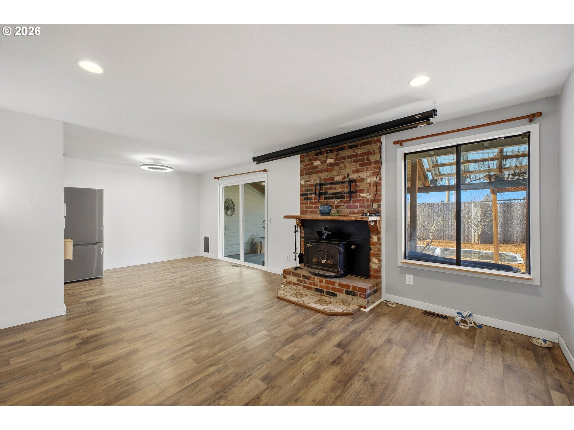 21858 Southwest Regal Court Beaverton, OR 97003 - Photo 5 of 29 a view of empty room with wooden floor and fireplace