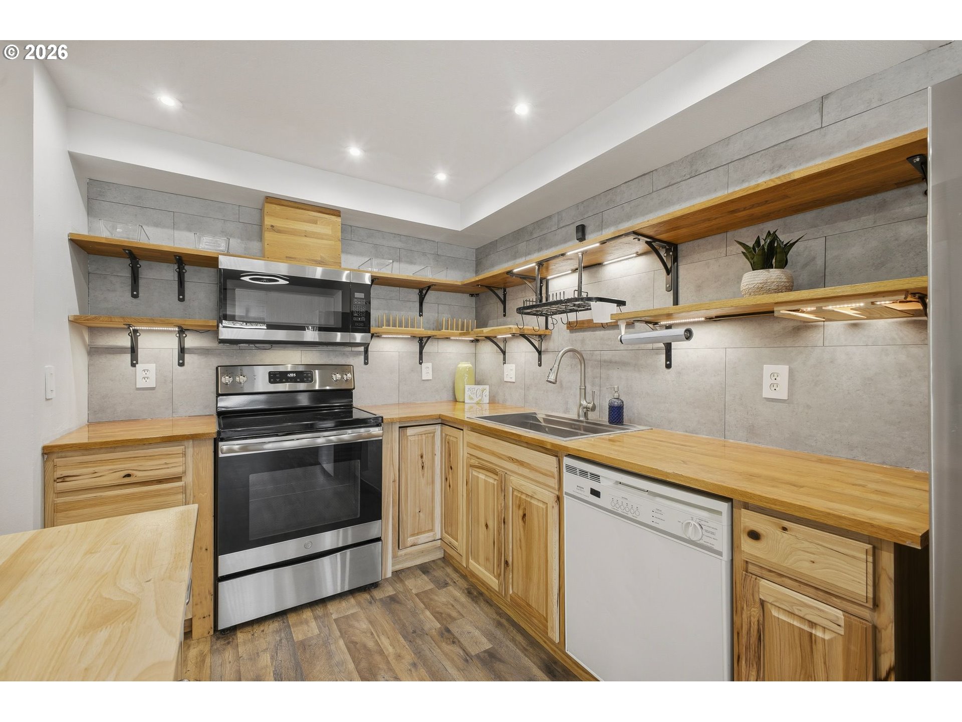 21858 Southwest Regal Court Beaverton, OR 97003 - Photo 8 of 29 a kitchen with stainless steel appliances granite countertop a sink a stove and a microwave