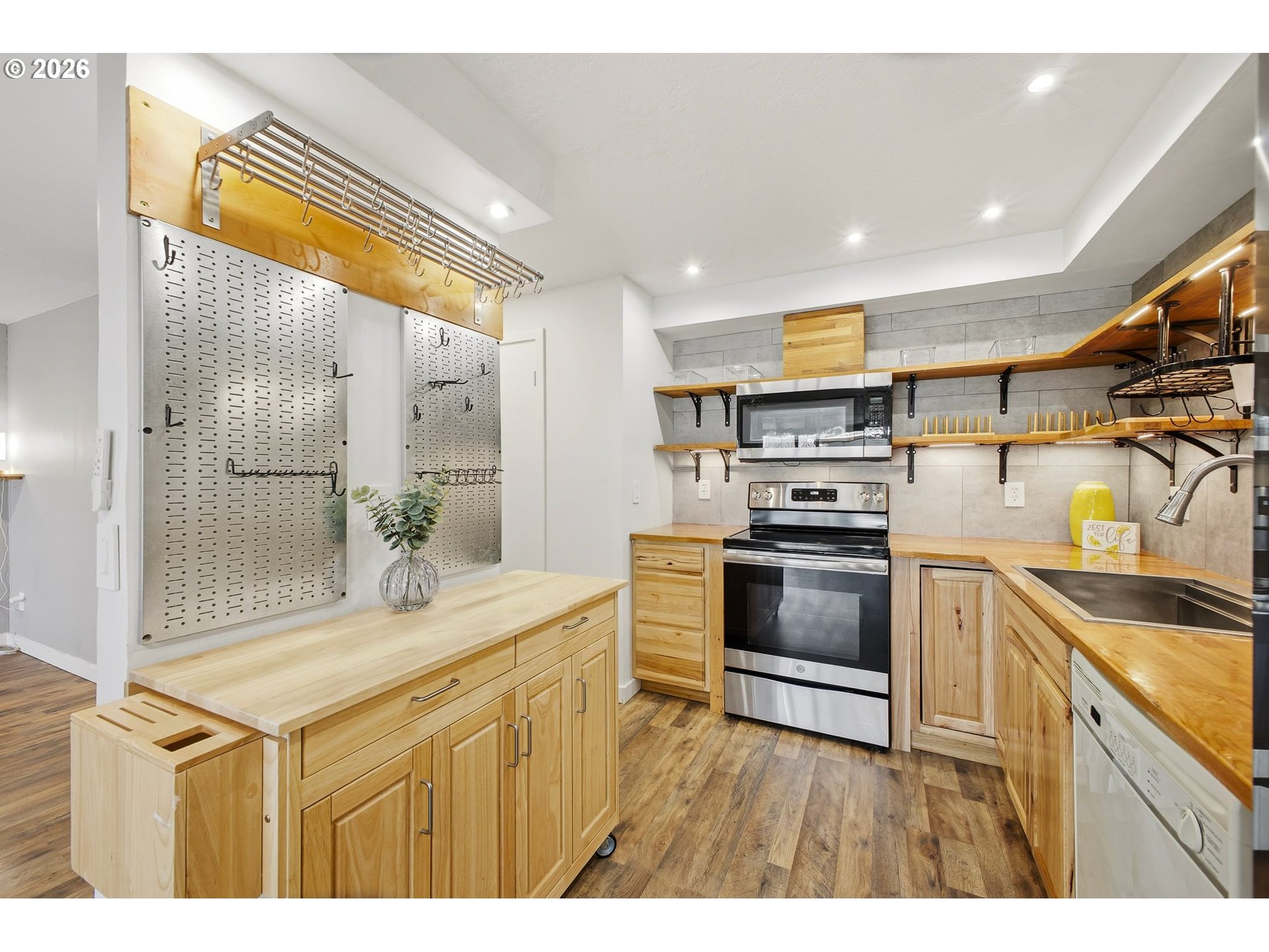 21858 Southwest Regal Court Beaverton, OR 97003 - Photo 9 of 29 a kitchen with kitchen island granite countertop a sink cabinets stainless steel appliances and a counter top space