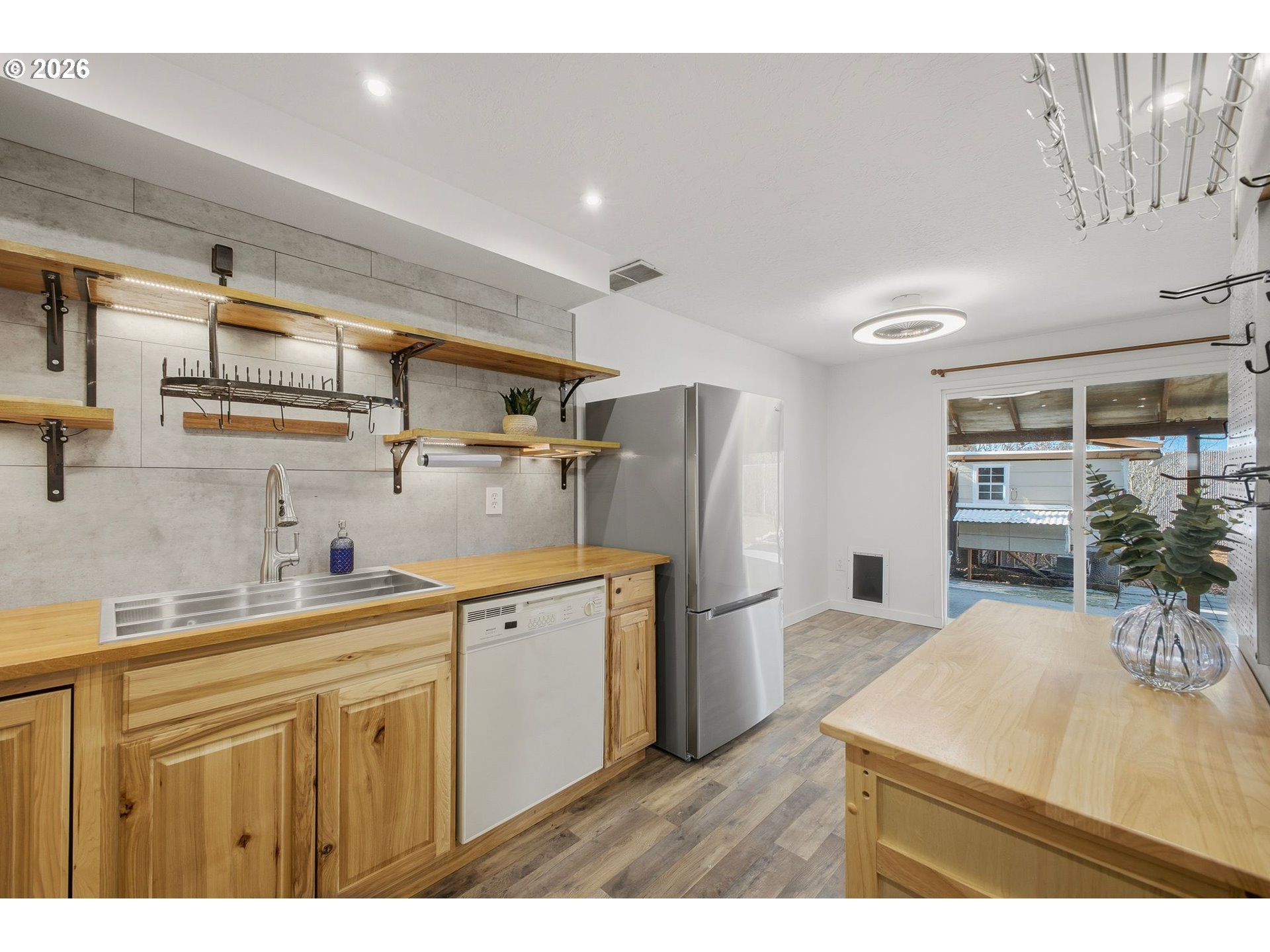 21858 Southwest Regal Court Beaverton, OR 97003 - Photo 10 of 29 a kitchen with stainless steel appliances a sink a refrigerator a stove a dining table and chairs