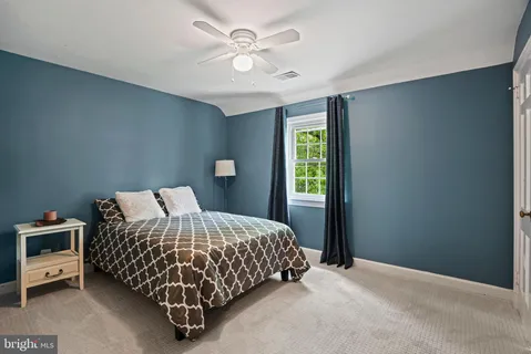 a bedroom with a bed and a ceiling fan