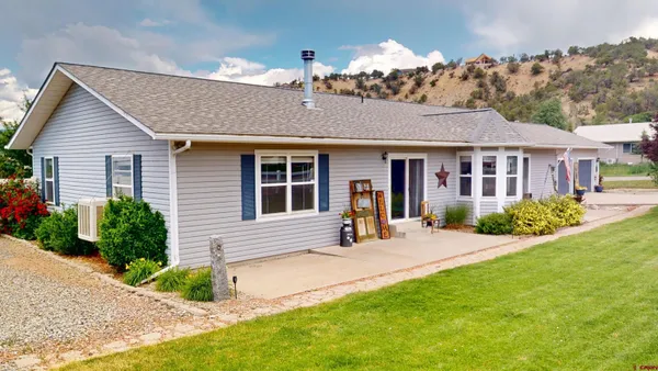 a front view of a house with a yard outdoor seating and garage