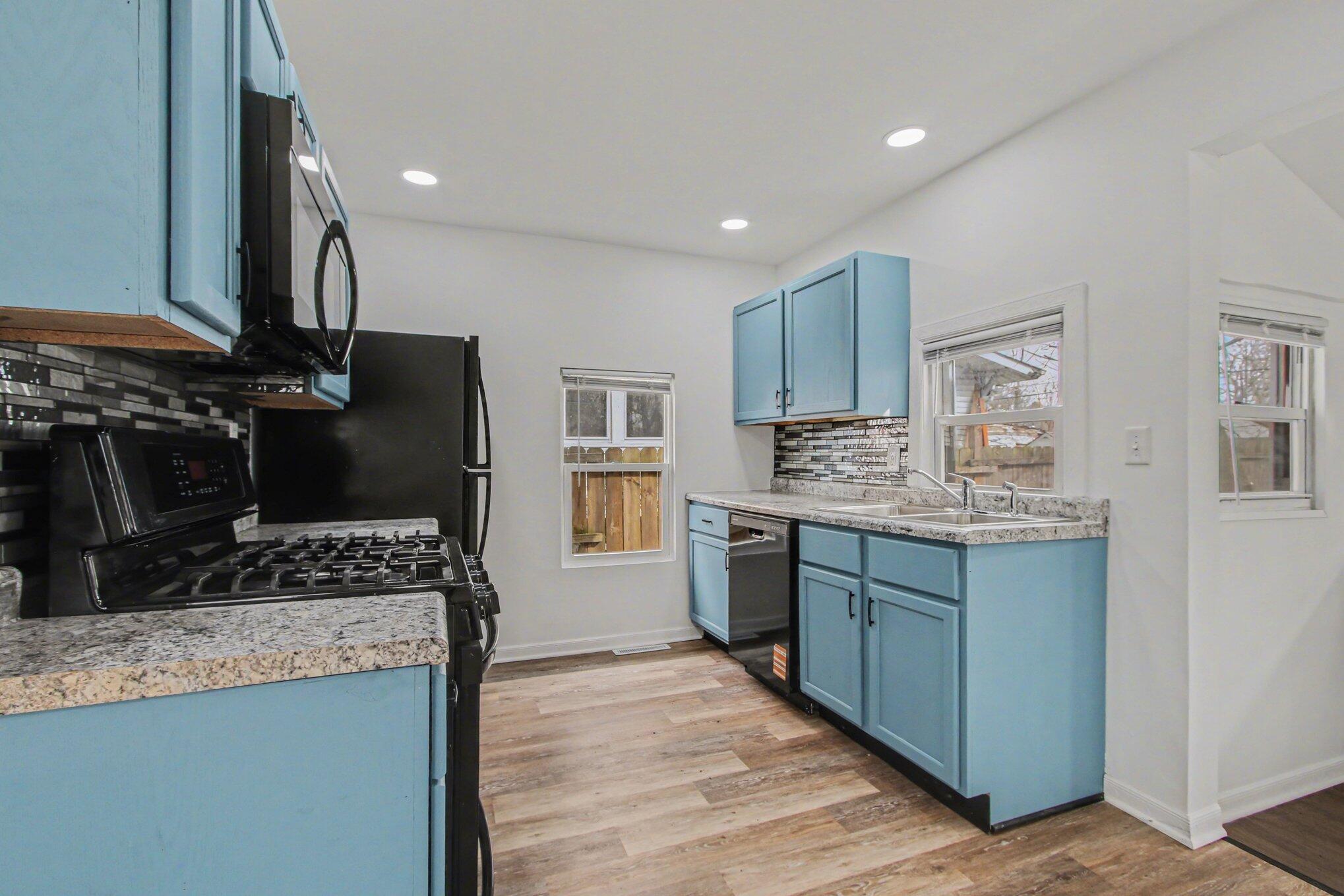 4471 Massachusetts Street Gary, IN 46409 - Photo 3 of 24 a kitchen with granite countertop a sink stove and cabinets