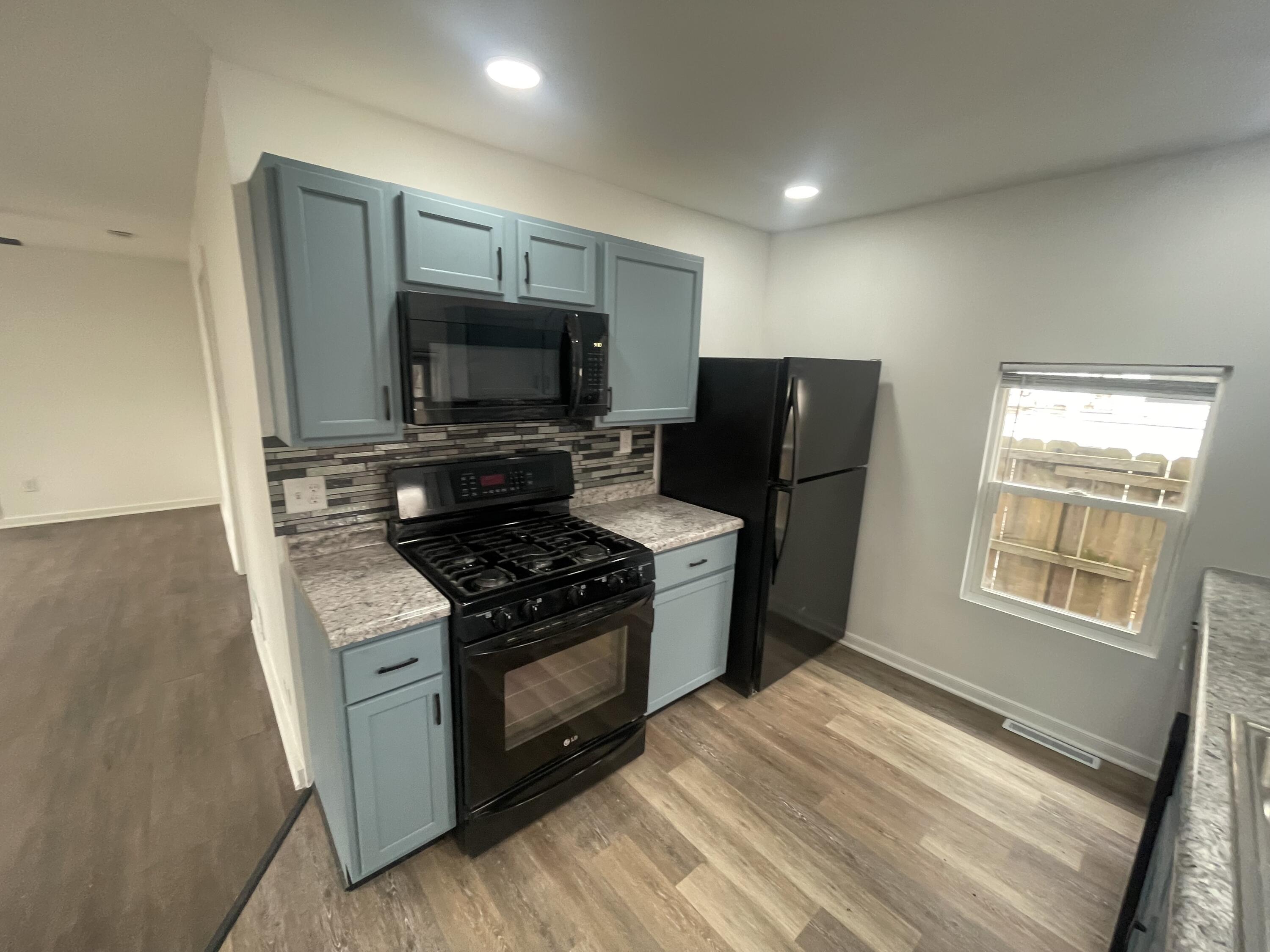 4471 Massachusetts Street Gary, IN 46409 - Photo 7 of 24 a kitchen with granite countertop a stove top oven and refrigerator