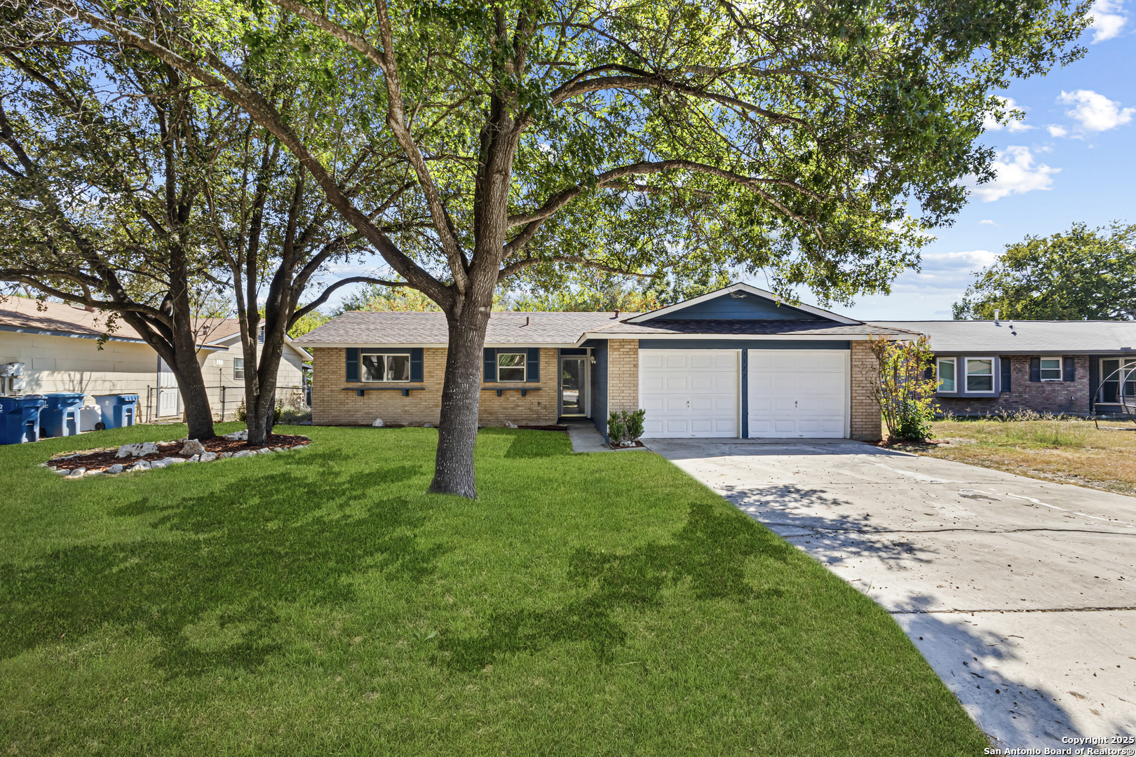 a front view of a house with a garden and trees