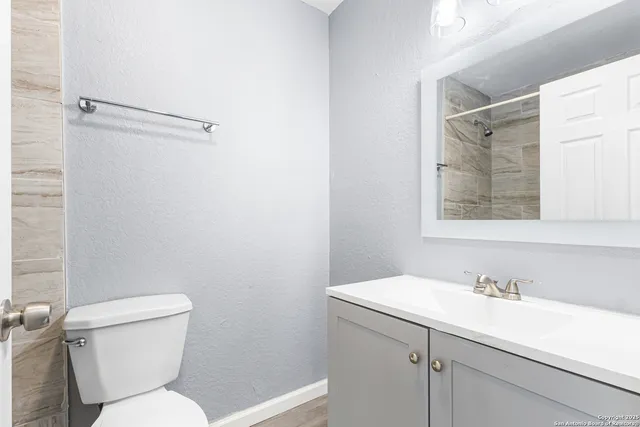 a bathroom with a toilet sink and mirror