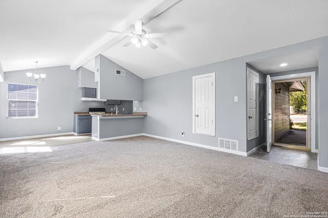 an empty room with windows and ceiling fan
