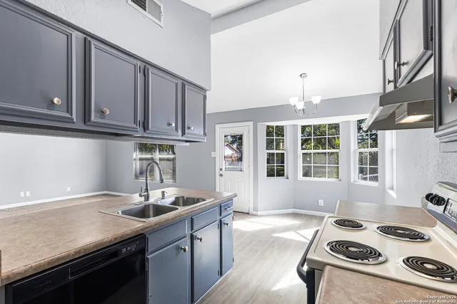 a kitchen with granite countertop a sink stove and cabinets