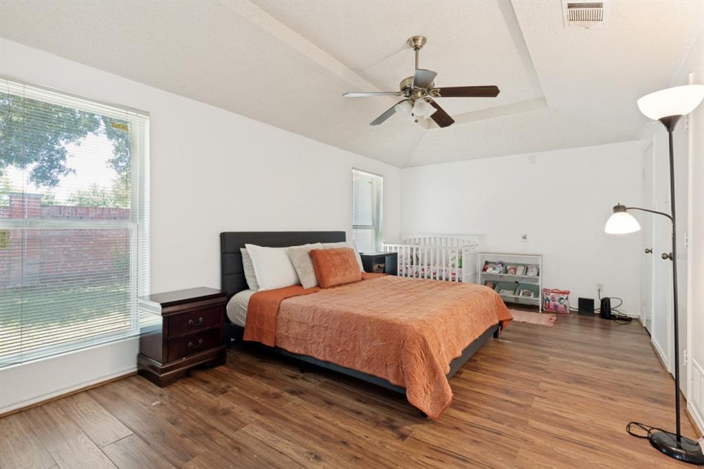 7410 Jessica Way Rowlett, TX 75088 - Photo 19 of 25 a bedroom with a bed a window and a chandelier
