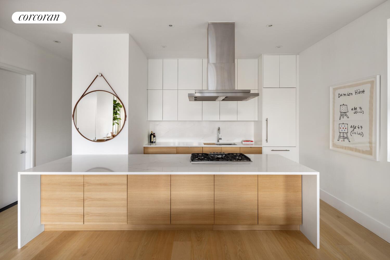 72 Mercer Street, Unit 5W Manhattan, NY 10012 - Photo 7 of 17 a kitchen with kitchen island granite countertop a white cabinets and a sink