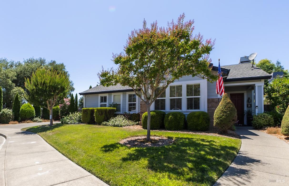 a front view of a house with a yard and potted plants