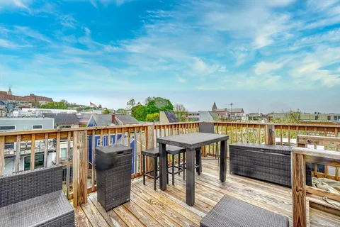 a view of roof deck with seating space and wooden floor