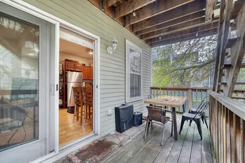 a view of a patio with table and chairs with wooden floor and floor to ceiling windows