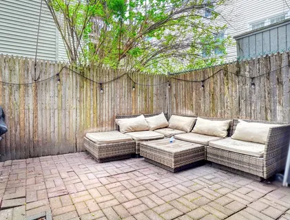 a view of a patio with furniture and wooden fence