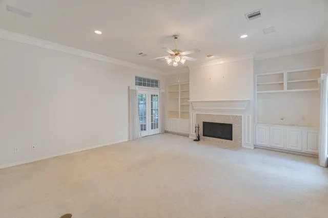 en empty room with windows and fireplace