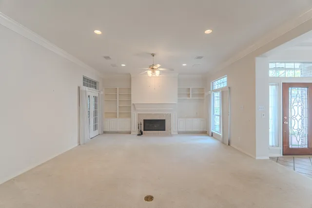 a view of an empty room with a fireplace and a window