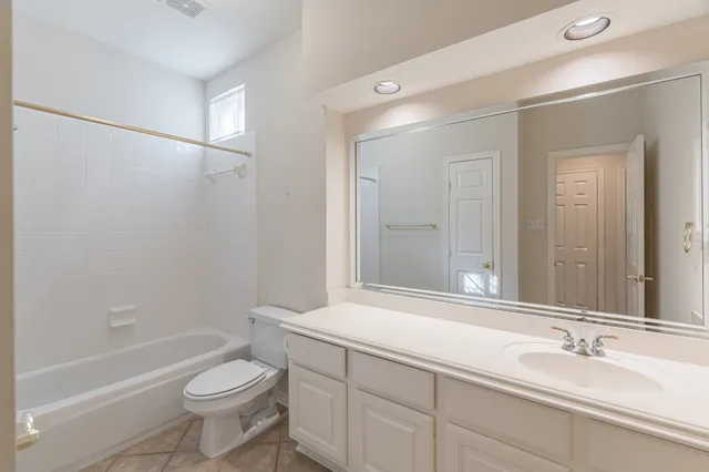 a bathroom with a double vanity sink toilet mirror and bathtub