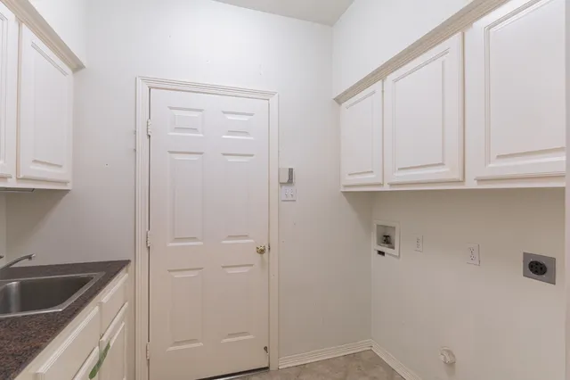 a kitchen with white cabinets and sink