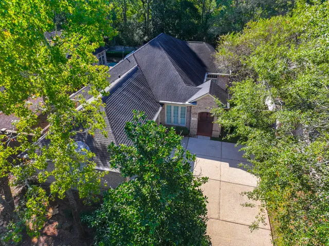 an aerial view of house with yard and trees in the background