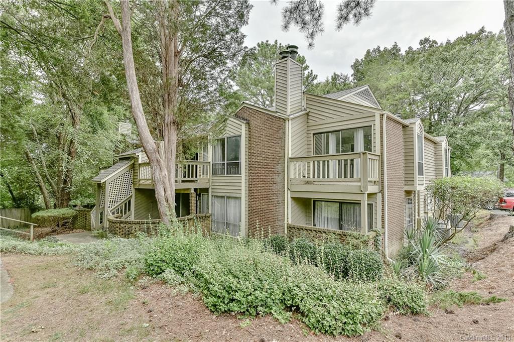 1606 Sharon Road West, Unit 34 Charlotte, NC 28210 - Photo 1 of 18 a front view of a house with a garden