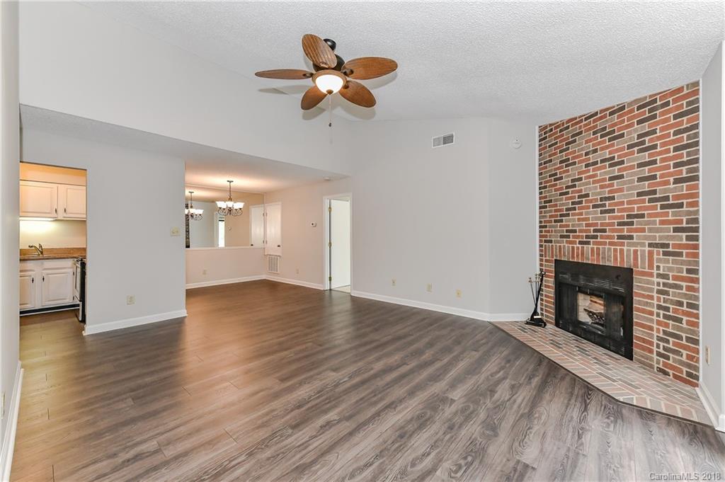 1606 Sharon Road West, Unit 34 Charlotte, NC 28210 - Photo 4 of 18 a view of a livingroom with wooden floor and a fireplace
