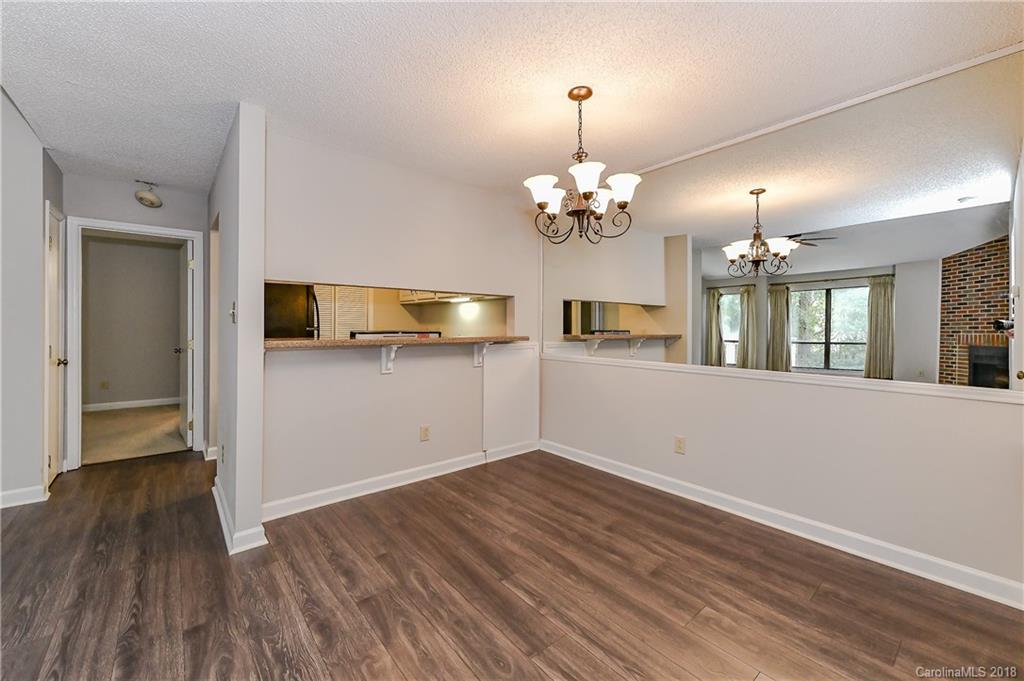 1606 Sharon Road West, Unit 34 Charlotte, NC 28210 - Photo 6 of 18 a view of a room with wooden floor and chandelier