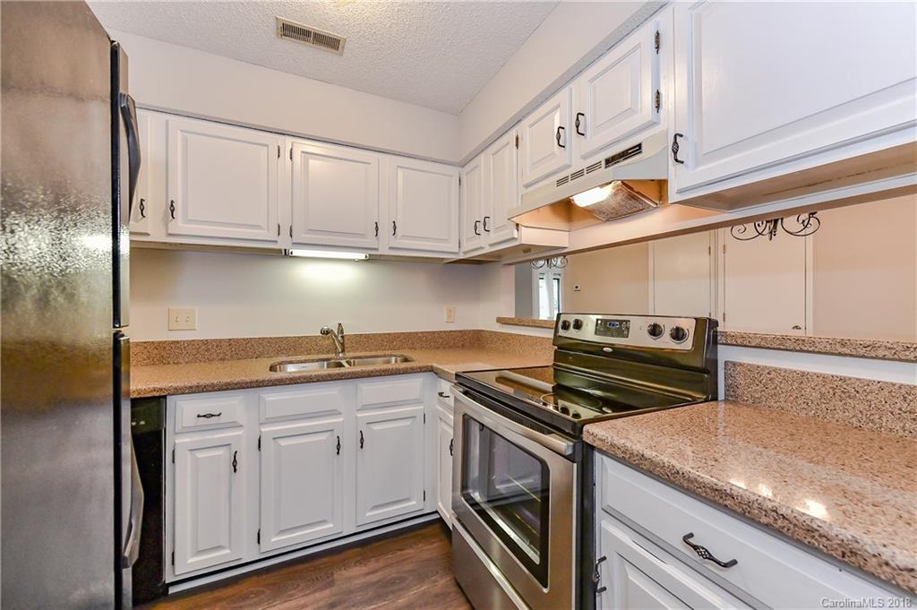 1606 Sharon Road West, Unit 34 Charlotte, NC 28210 - Photo 7 of 18 a kitchen with cabinets appliances a sink and a counter top space