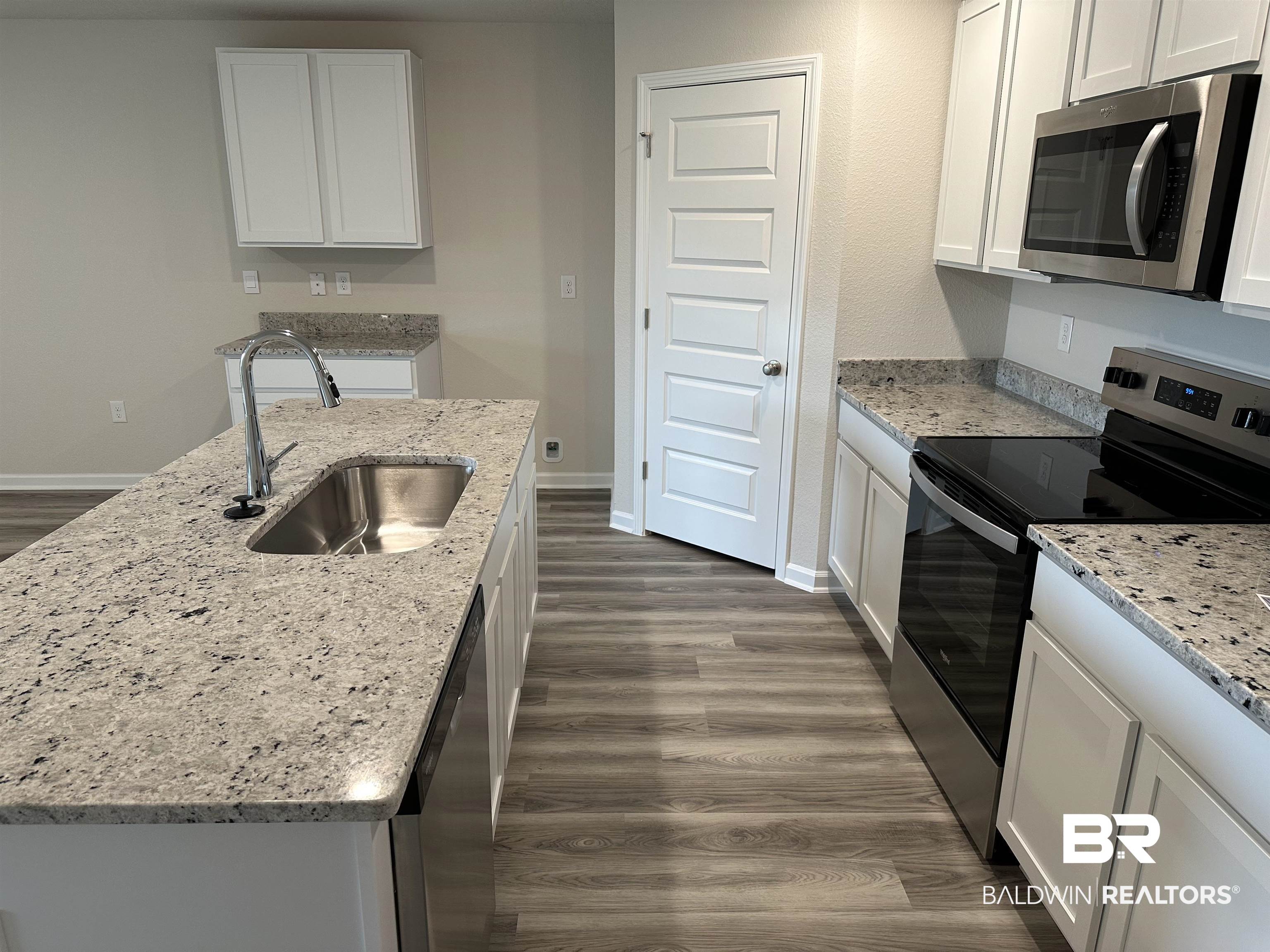 1238 Hayward Loop Foley, AL 36535 - Photo 22 of 46 Kitchen featuring white cabinetry, sink, dark hardwood / wood-style flooring, an island with sink, and appliances with stainless steel finishes