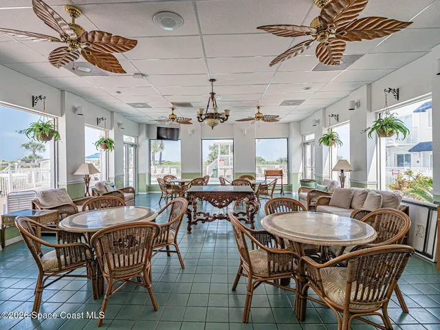a dining room with furniture a chandelier and wooden floor