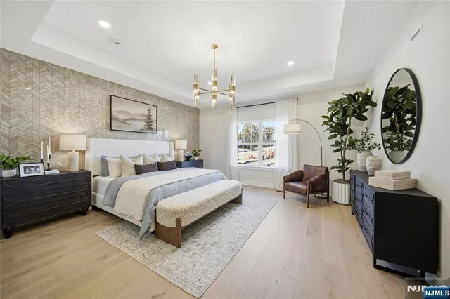 a spacious bedroom with a bed a dresser and window