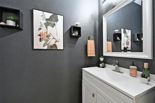 a bathroom with a sink vanity and a mirror