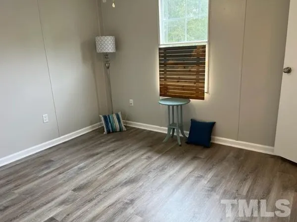 a view of room with a window and wooden floor