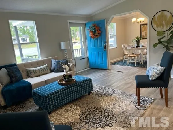 a living room with furniture a lamp wooden floor and a window