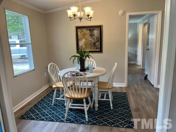 a dining room with furniture a rug and a window