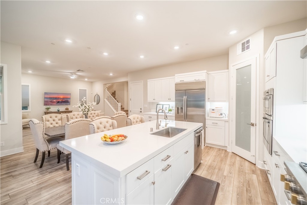 599 Serrano Summit Drive Lake Forest, CA 92630 - Photo 5 of 31 a large kitchen with sink a refrigerator and chairs