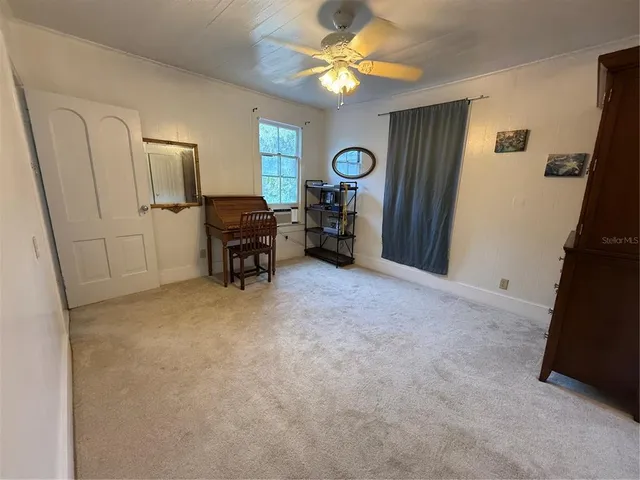 a view of an empty room with a fireplace and a fan