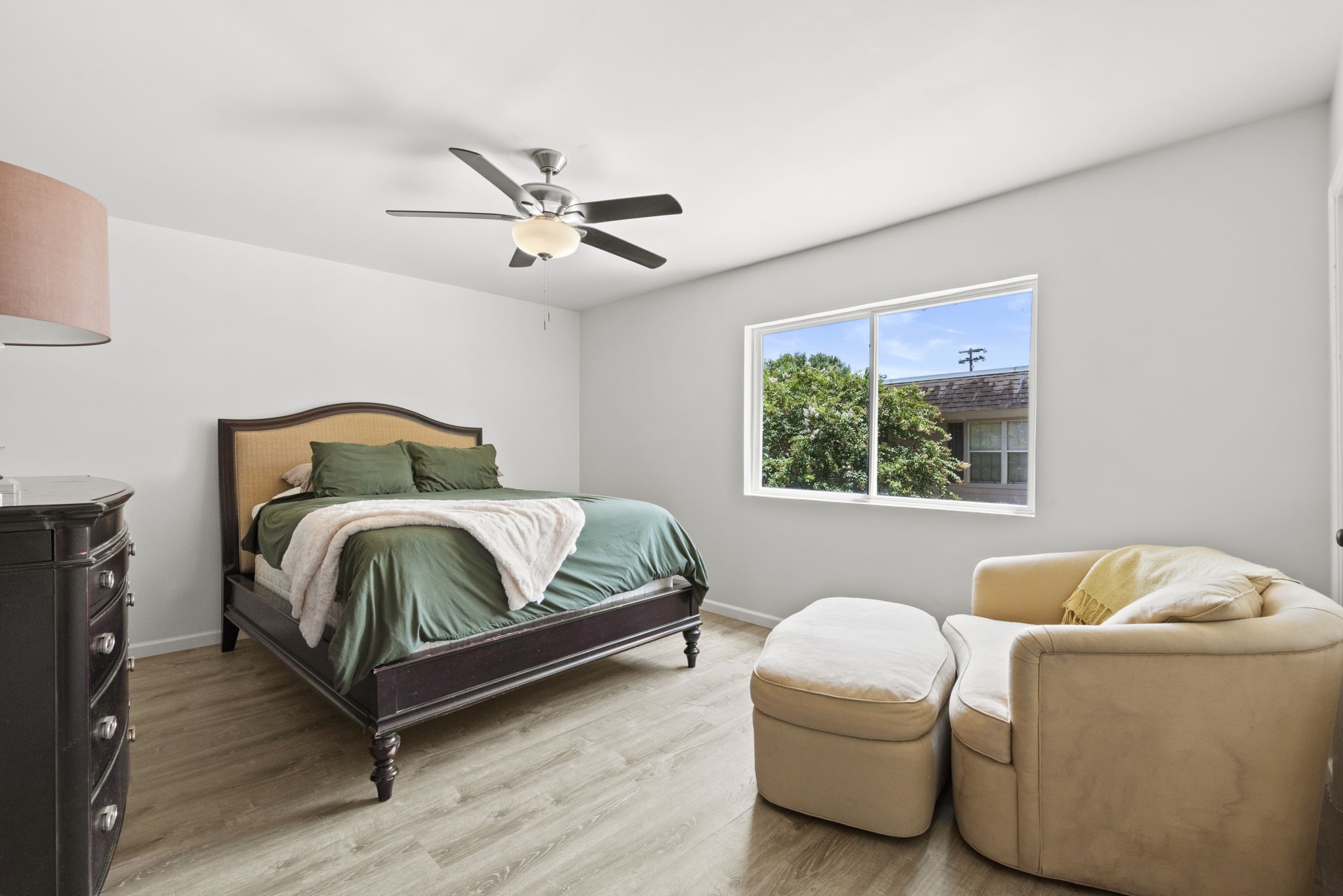 1115 Augusta Drive, Unit 26 Houston, TX 77057 - Photo 11 of 23 Spacious bedroom with light wood flooring, large window for natural light, and a serene blank canvas for personalized design and a cozy nook ideal for reading or relaxing.