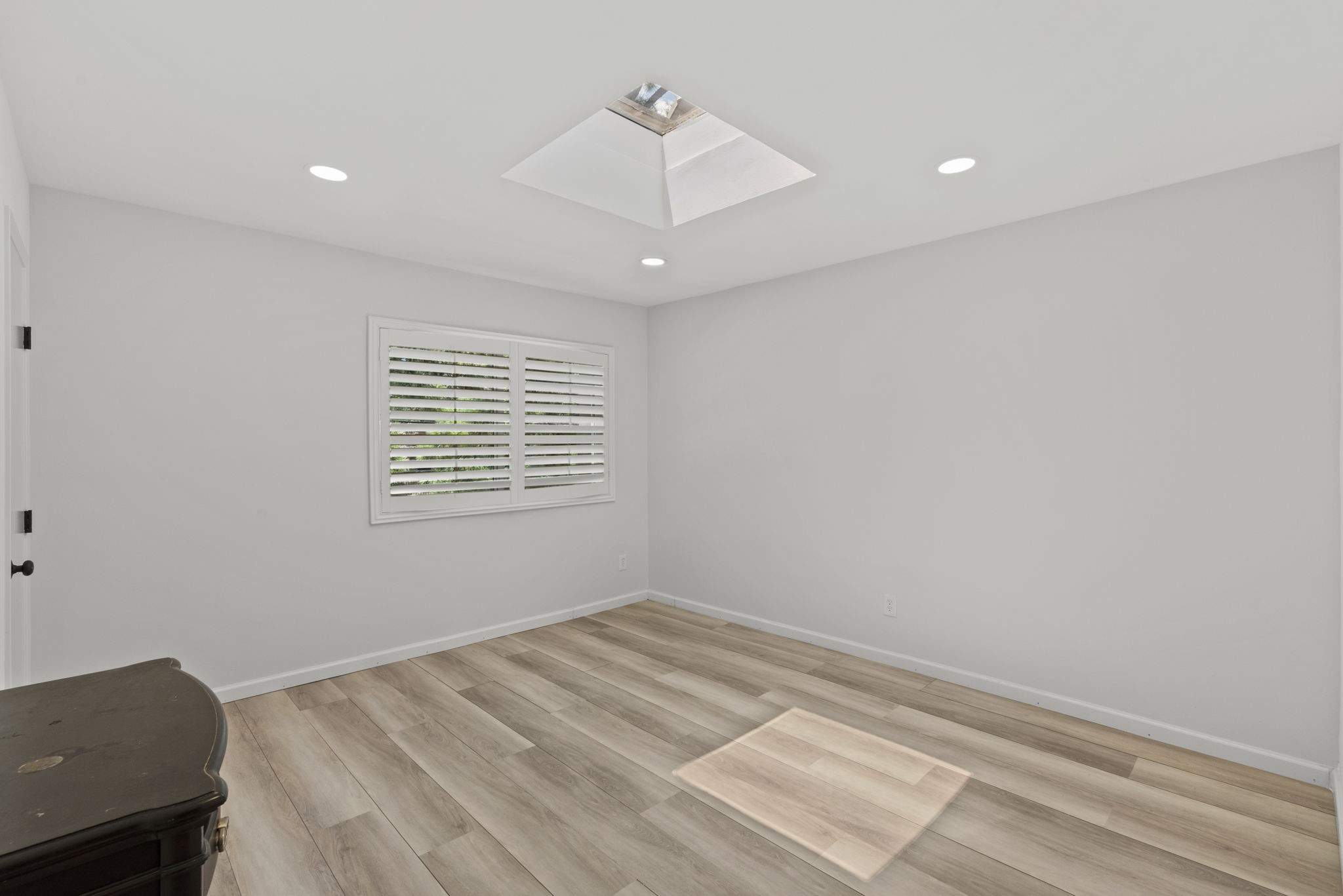 1115 Augusta Drive, Unit 26 Houston, TX 77057 - Photo 14 of 23 Bright and versatile space with light wood flooring, recessed lighting, and a skylight that fills the room with natural light — complete with plantation shutters for privacy and style.