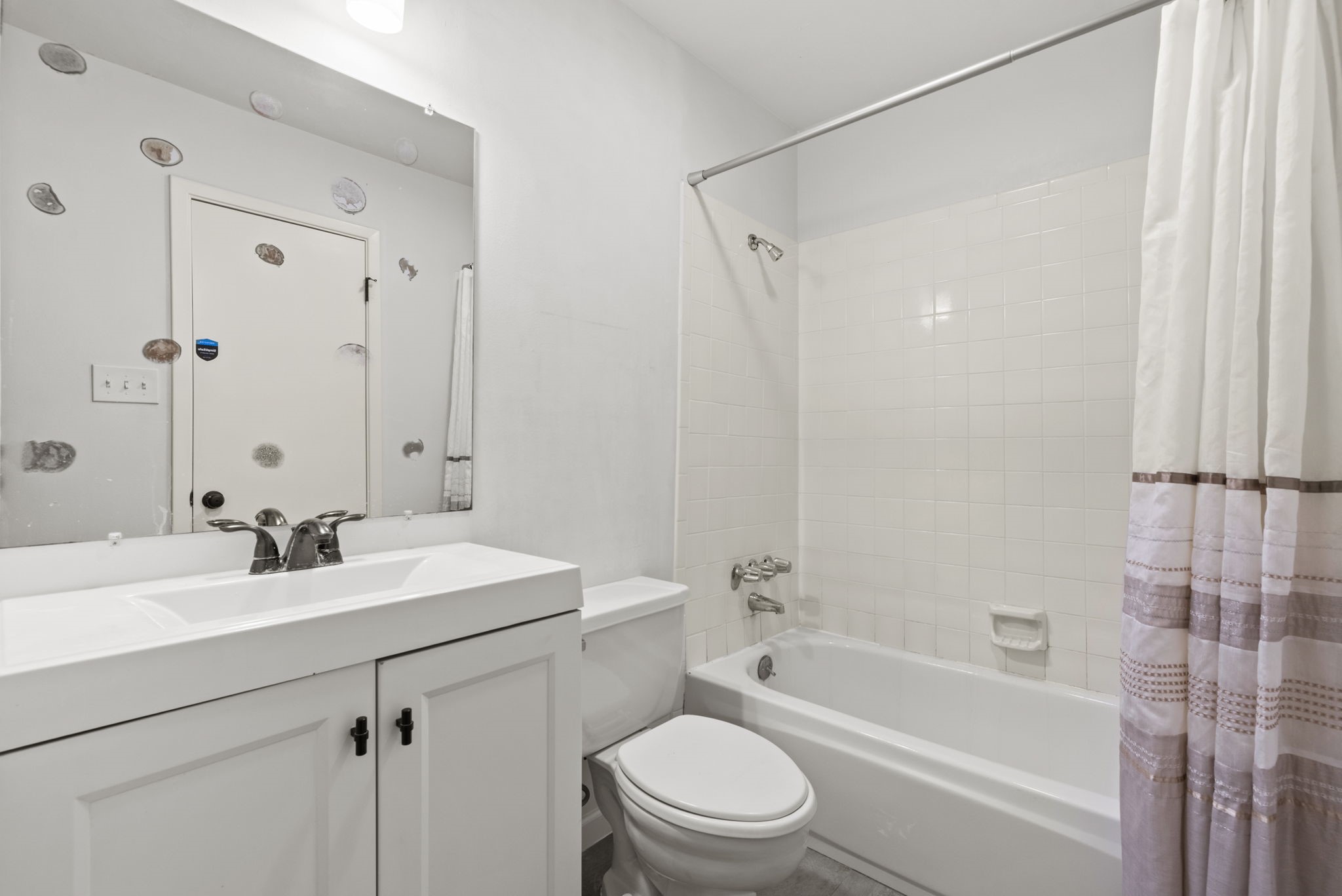 1115 Augusta Drive, Unit 26 Houston, TX 77057 - Photo 15 of 23 Secondary bathroom with white vanity, tiled shower/tub combo — a fresh space for daily routines.